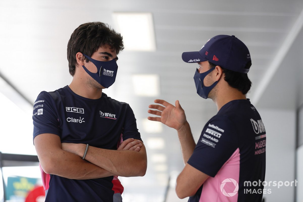 Lance Stroll, Racing Point, and Sergio Perez, Racing Point, talk outside the garage