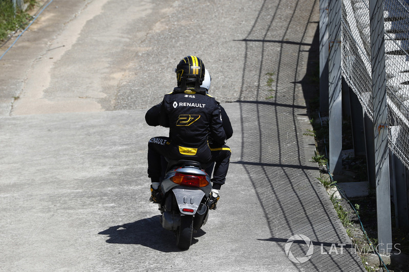 Nico Hulkenberg, Renault Sport F1 Team R.S. 18. receives a lift back to the pits on a moped