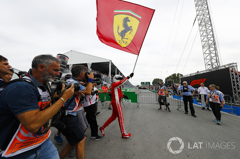 Sebastian Vettel, Ferrari, festeggia la vittoria sventolando una bandiera con il Cavallino Rampante