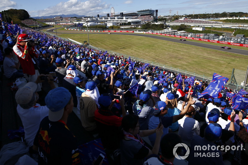 Fans with Toro Rosso flags wave as Brendon Hartley, Toro Rosso STR13, and Pierre Gasly, Scuderia Toro Rosso STR13, pass