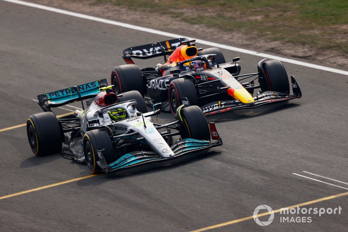 Lewis Hamilton, Mercedes W13, battles with Max Verstappen, Red Bull Racing RB18, for the lead after the restart