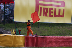 Een baanpost zwaait de rode vlag