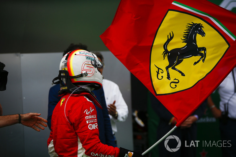 Sebastian Vettel, Ferrari, festeggia la vittoria sventolando una bandiera con il Cavallino Rampante