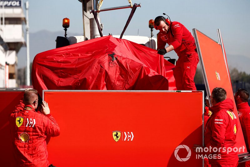 The car of Sebastian Vettel, Ferrari SF90 is recovered to the garage shielded by screens
