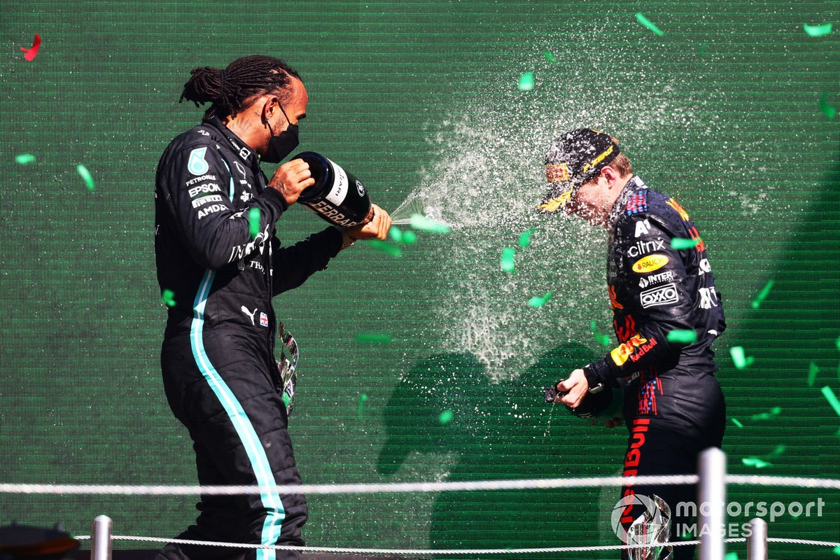 Lewis Hamilton, Mercedes, 2nd position, and Sergio Perez, Red Bull Racing, 3rd position, celebrate on the podium