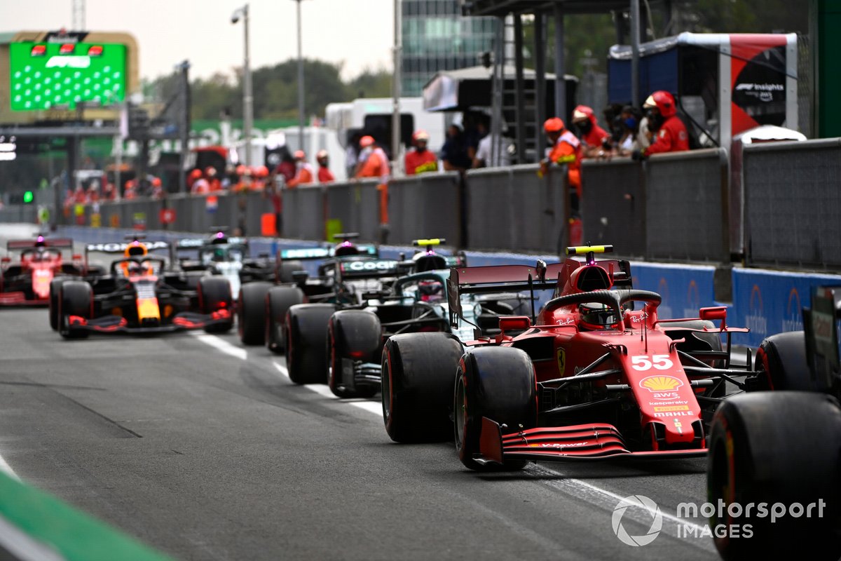 Carlos Sainz Jr., Ferrari SF21, Sebastian Vettel, Aston Martin AMR21, dan mobil lain di pit lane