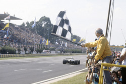 Carlos Reutemann, Williams FW07C-Ford Cosworth ve damalı bayrağı sallayan Juan Manuel Fangio