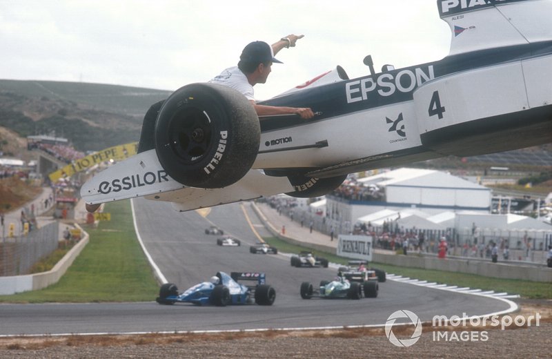 Marshalls remove the car of Jean Alesi Tyrrell 019 Ford from the track
