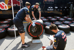 Red Bull Racing mechanics weigh a Pirelli tyre