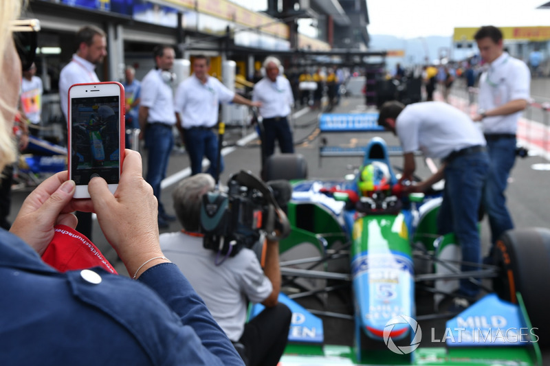 Sabine Kehm, takes a photo of Mick Schumacher, Benetton B194