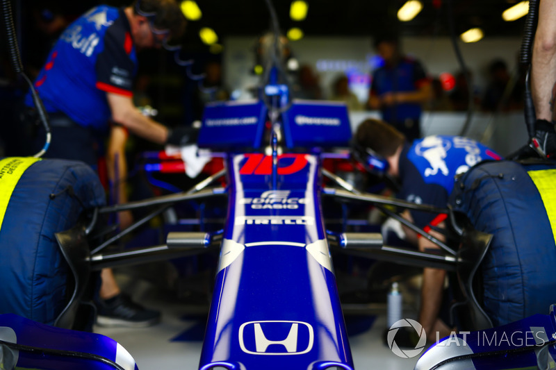 Engineers work on the car of Pierre Gasly, Toro Rosso STR13 Honda, in the garage