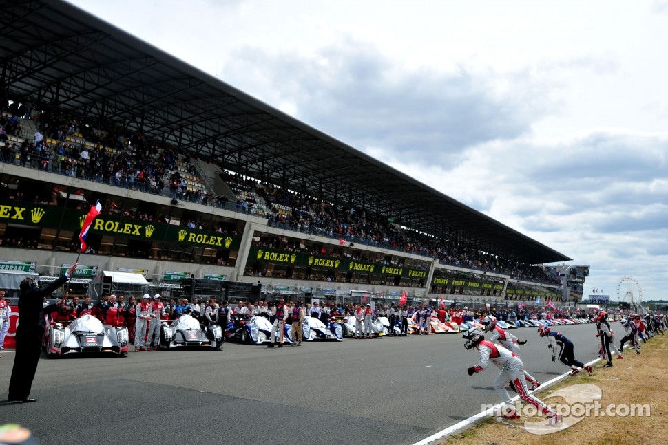 Drivers run to their cars for the simulated start