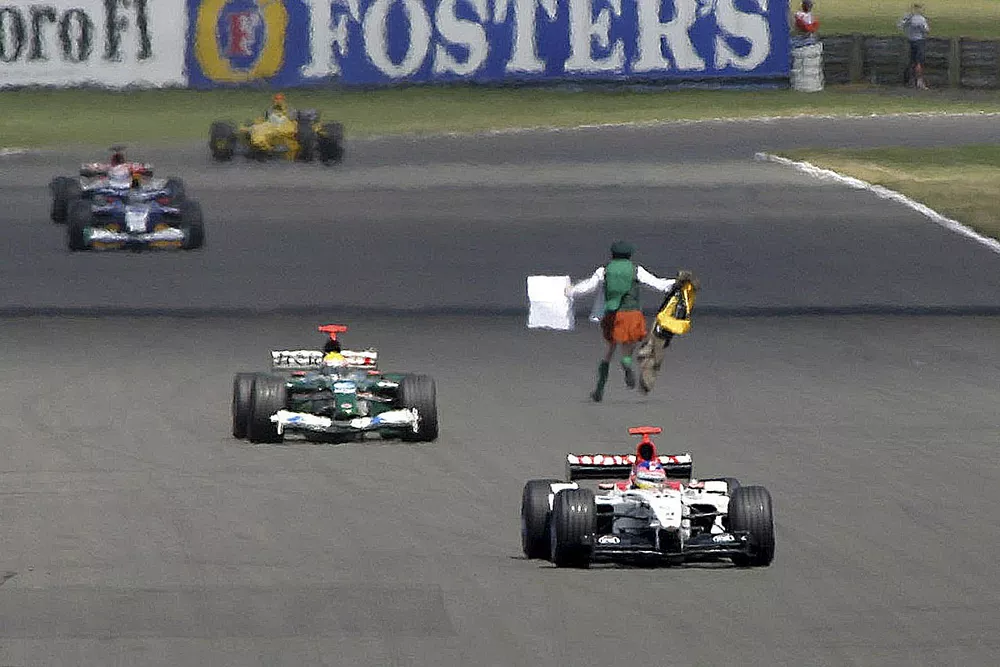 Un hombre pasa frente a los coches en pista