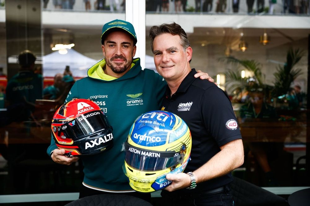 Fernando Alonso, Aston Martin F1 Team, se intercambia el casco con la estrella de la NASCAR Jeff Gordon
