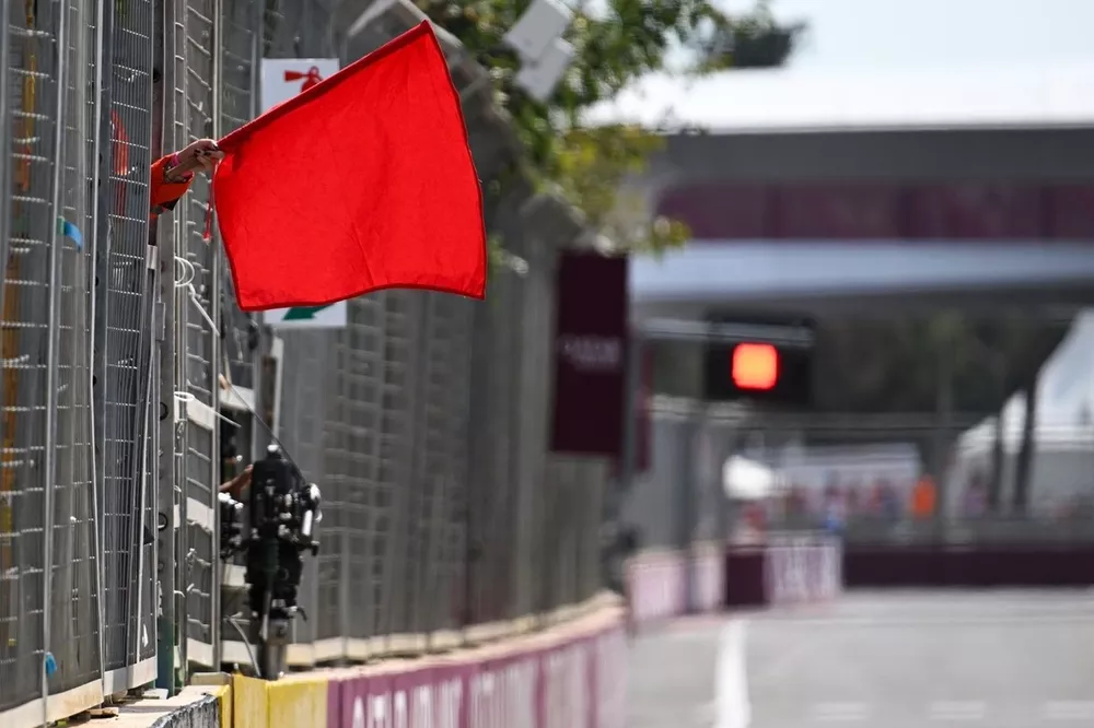 Les commissaires agitent le drapeau rouge