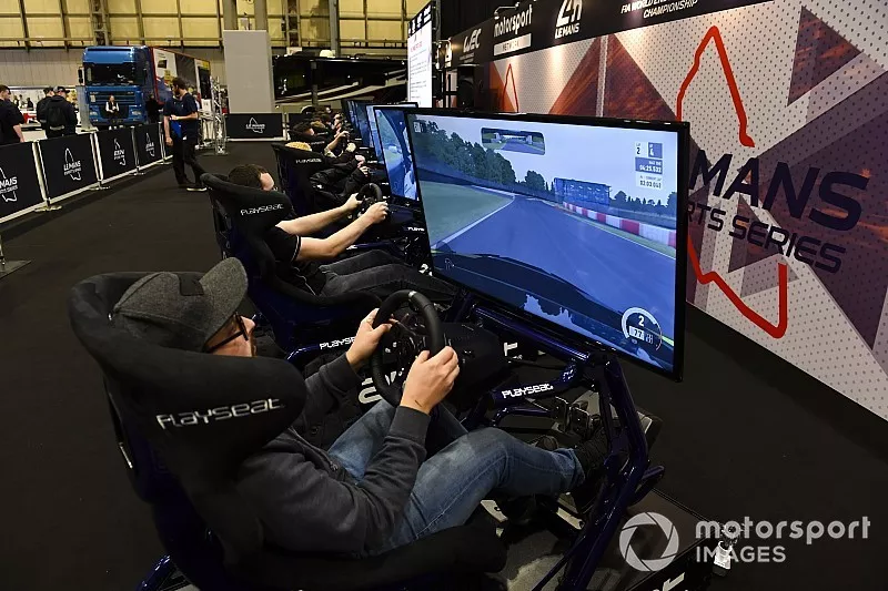 Visitors play an esports simulator game on the WEC Le Mans Esports stand