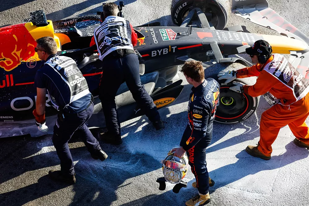 Los oficiales de pista asisten a Max Verstappen, de Red Bull Racing, tras retirarse de la carrera