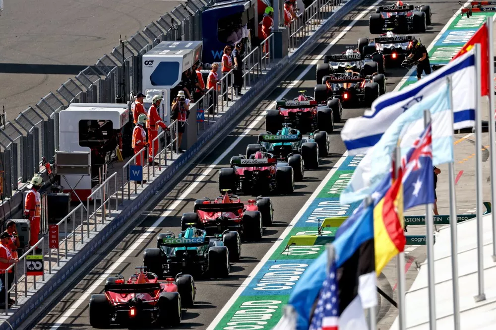 Sergio P&eacute;rez, Red Bull Racing RB19, lidera Yuki Tsunoda, AlphaTauri AT04, Daniel Ricciardo, AlphaTauri AT04, Lando Norris, McLaren MCL60, Zhou Guanyu, Alfa Romeo C43, Lance Stroll, Aston Martin AMR23, Valtteri Bottas, Alfa Romeo C43, formados en pit lane.