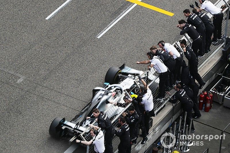 Lewis Hamilton, Mercedes AMG F1 W10 crosses the finish line in front of his team celebrating 