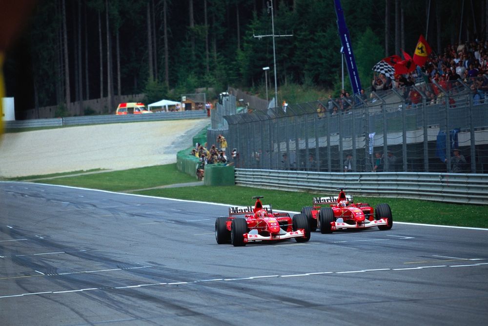 Michael Schumacher, Ferrari F2002, adelantando a su compañero Rubens Barrichello en la línea de meta después de que Ferrari ordenara que Michael ganara