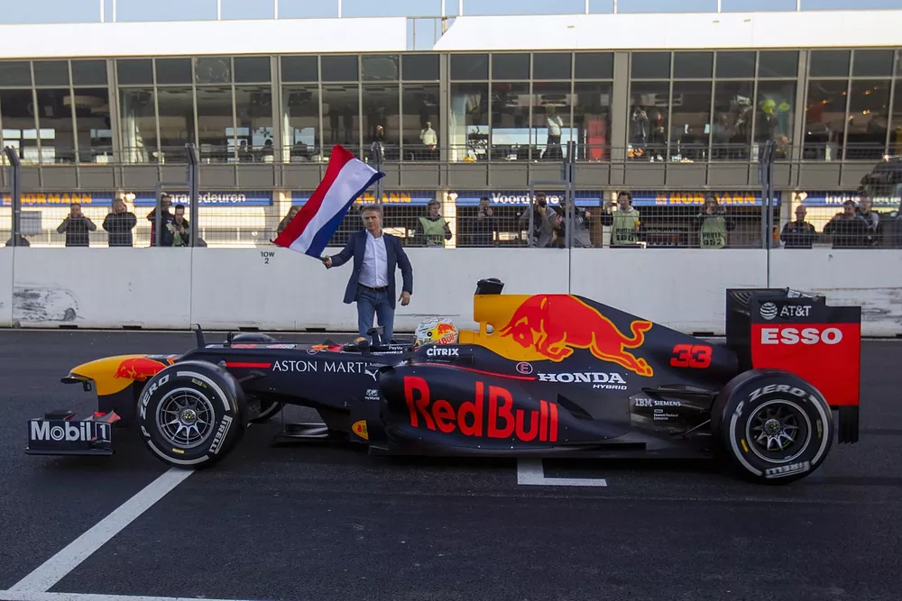 Max Verstappen, RB8, at the start/finish of Circuit Zandvoort with Jan Lammers waiving the Dutch flag