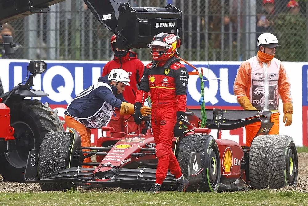 Los oficiales asisten a Carlos Sainz Jr., Ferrari F1-75, en la grava