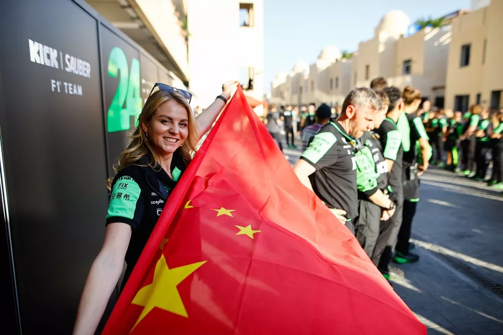 Un membre de l'&eacute;quipe Stake F1 Team KICK Sauber tient un drapeau chinois.