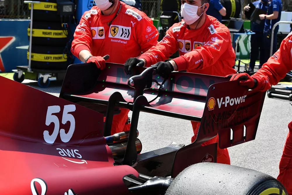 Mec&aacute;nicos en la parrilla con el coche de Carlos Sainz Jr., Ferrari SF21
