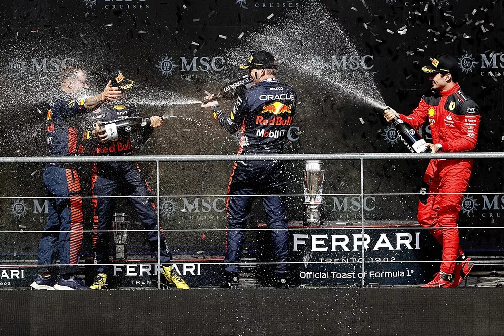 The Red Bull trophy delegate, Sergio Perez, Red Bull Racing, 2nd position, Max Verstappen, Red Bull Racing, 1st position, Charles Leclerc, Scuderia Ferrari, 3rd position, celebrate on the podium with Champagne