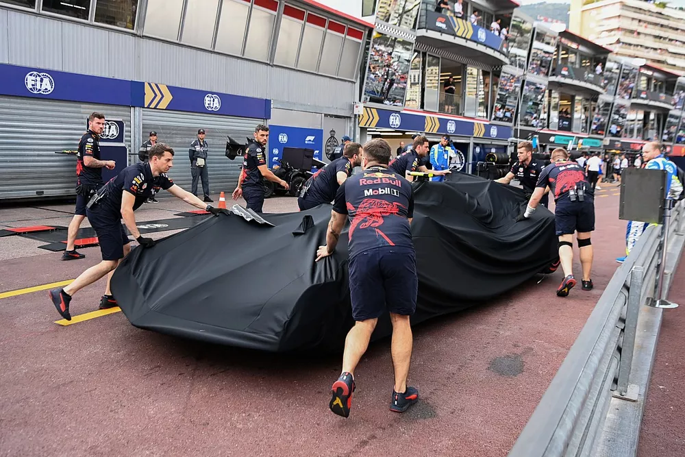 Mec&aacute;nicos con el coche da&ntilde;ado de Sergio P&eacute;rez, Red Bull Racing RB18, bajo una lona