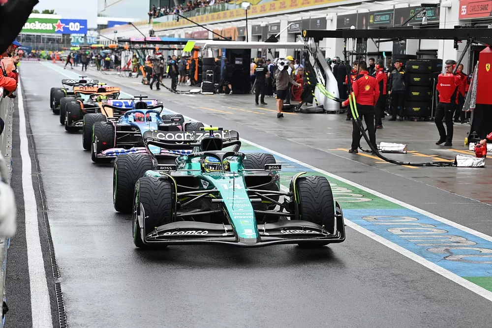 Fernando Alonso, Aston Martin AMR23, Esteban Ocon, Alpine A523, Lando Norris, McLaren MCL60, in the queue to leave the pits