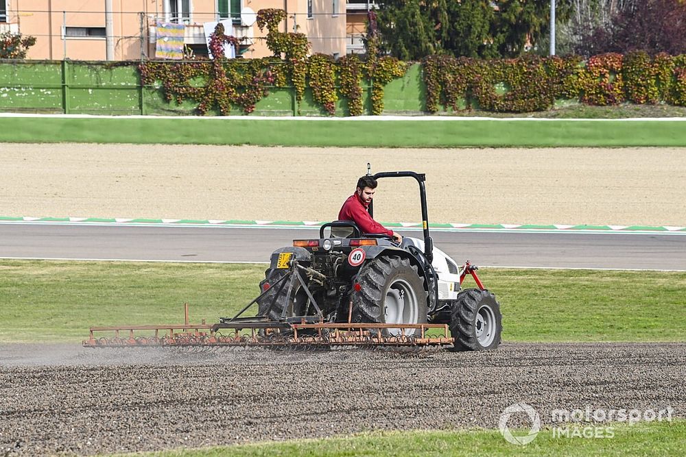 Una trampa de grava se rastrilla y se riega con un tractor.