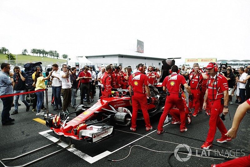 Equipo Ferrari frenéticamente intenta arreglar el SF70H de Ferrari de Kimi Raikkonen en la red, el periodista Jonathan Noble mira