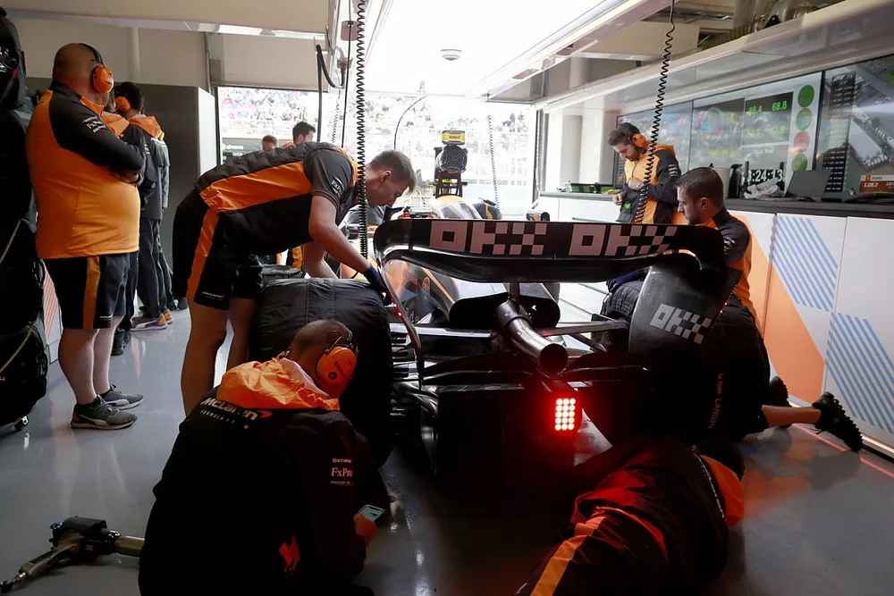 Des m&eacute;caniciens travaillent sur la monoplace de Lando Norris, McLaren MCL36, dans le garage
