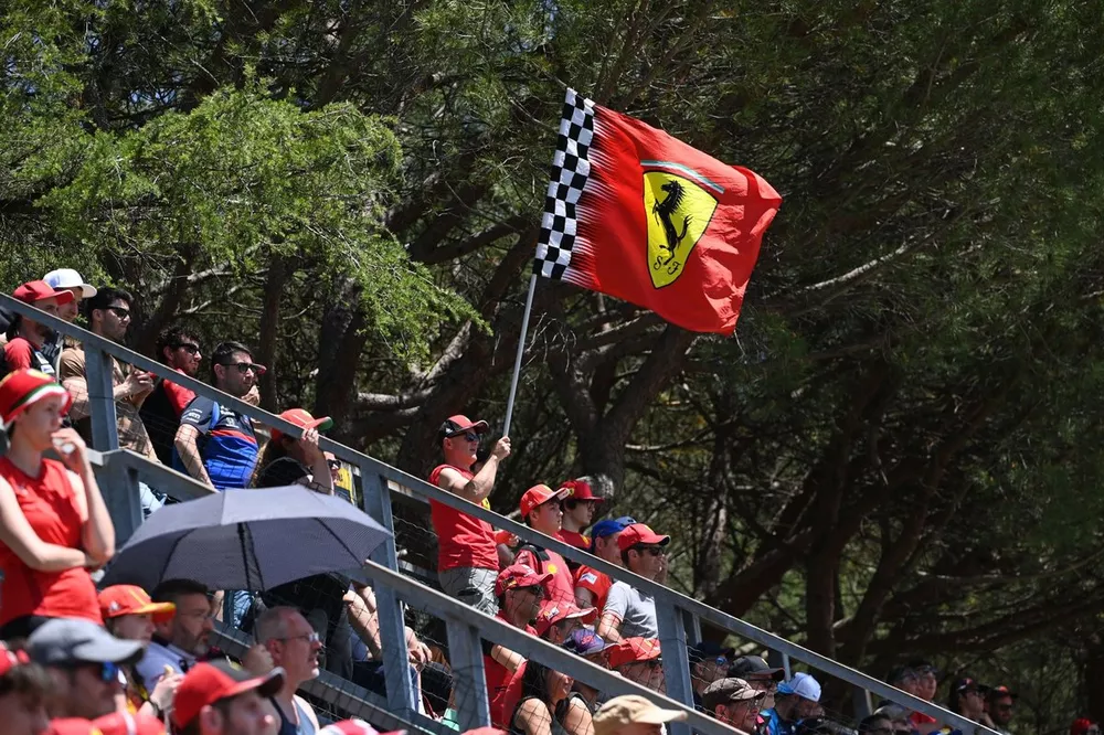Fans wave a Ferrari flag in a grandstand