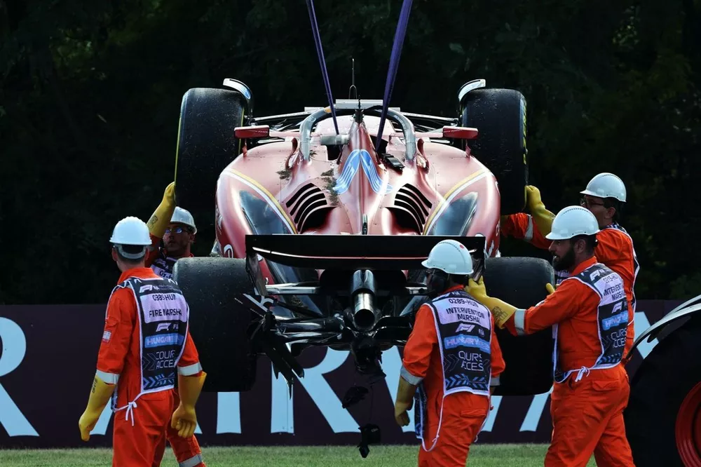 Marshals remove the damaged car of Charles Leclerc, Ferrari SF-24, from the circuit