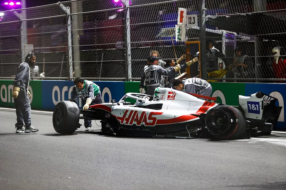 Los oficiales de pista recuperan los restos del coche dañado de Mick Schumacher, Haas VF-22, tras un fuerte accidente en la Q2