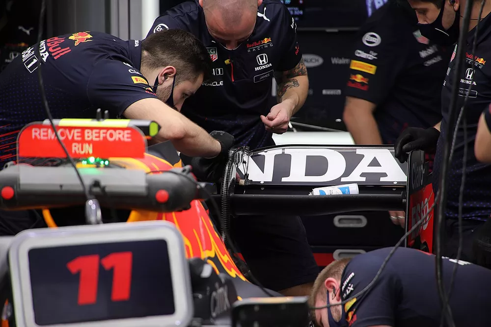 Miembros del equipo Red Bull Racing trabajando en el aler&oacute;n trasero