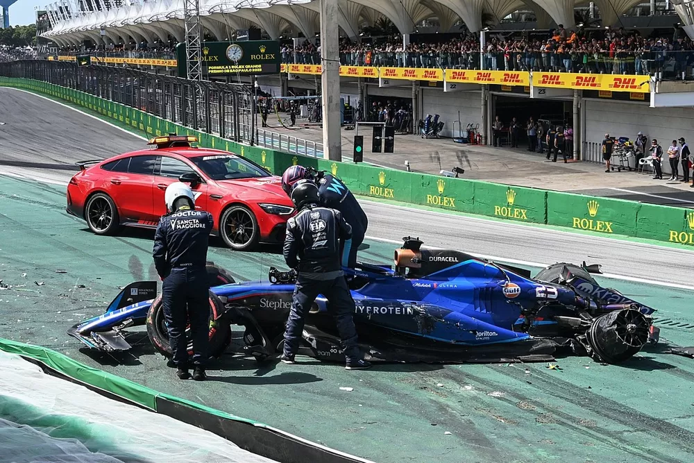 FIA medical delegates assist Alex Albon, Williams FW45, after a crash at the start with Kevin Magnussen, Haas VF-23