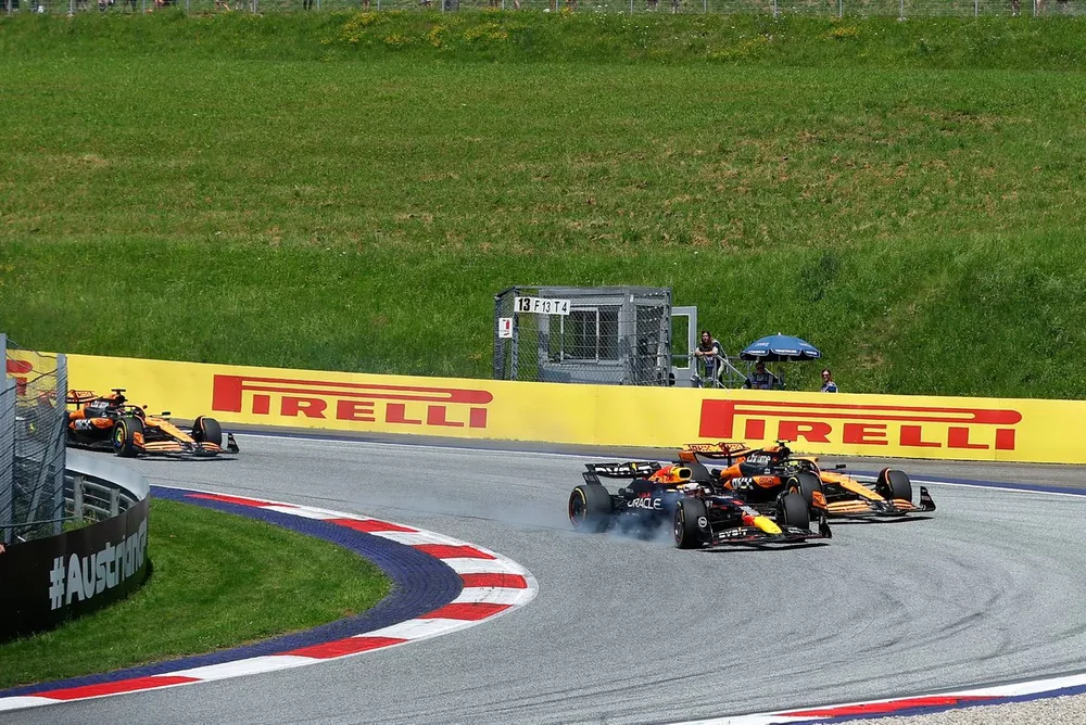 Max Verstappen, Red Bull Racing RB20, locks up with Lando Norris, McLaren MCL38 just behind