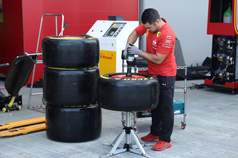 Un mec&aacute;nico de Ferrari trabajando en los neum&aacute;ticos de Pirelli