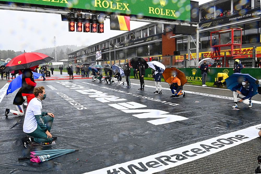 Los pilotos se ponen en pie y se arrodillan en la parrilla de salida en apoyo de la campaña Fin del Racismo