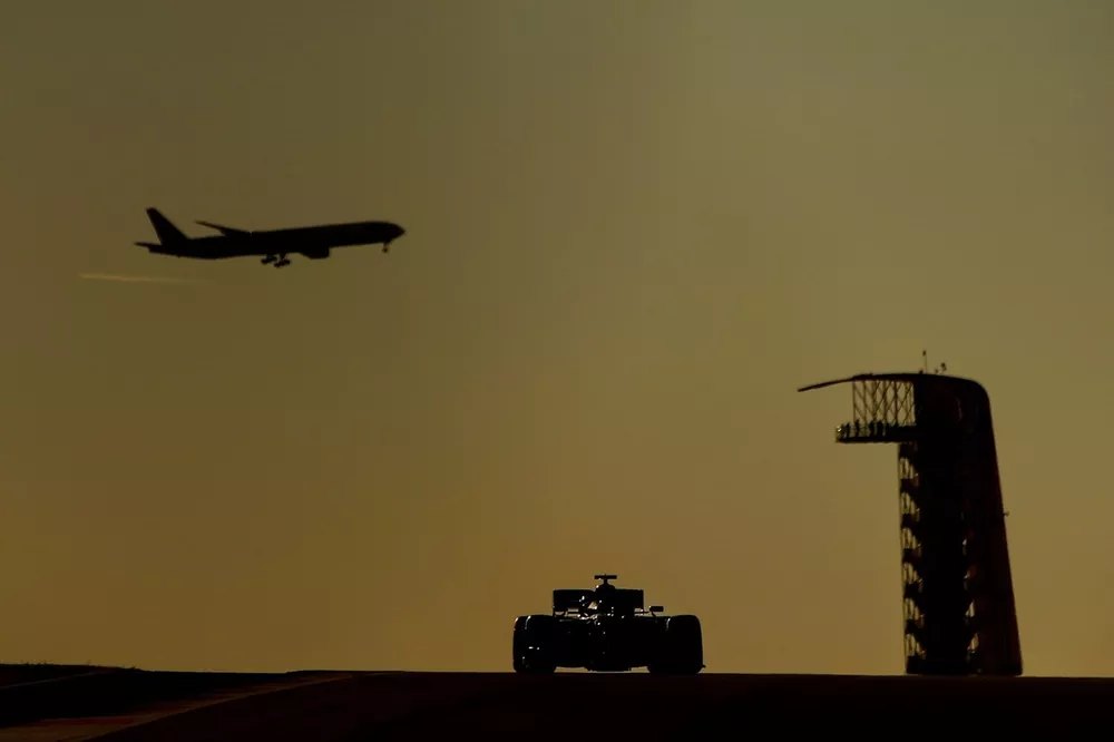 Un avion de ligne dans le ciel alors qu'une monoplace est en piste &agrave; Austin