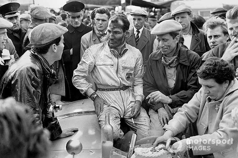 Stirling Moss, John Fitch, Mercedes-Benz 300SLR chat to photo-journalist, Bernard Cahier, whilst Moss's mother cuts his 26th birthday cake