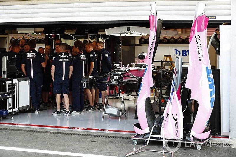 Mechanics gather in the Force India garage, next to the Sergio Perez Force India VJM11