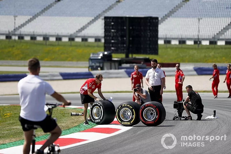 Sebastian Vettel, Ferrari aiuta a posizionare una gomma Pirelli durante un servizio fotografico