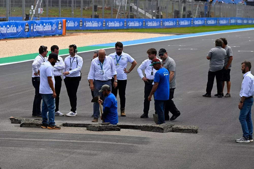 Officials repair a sinkhole on the start finish straight