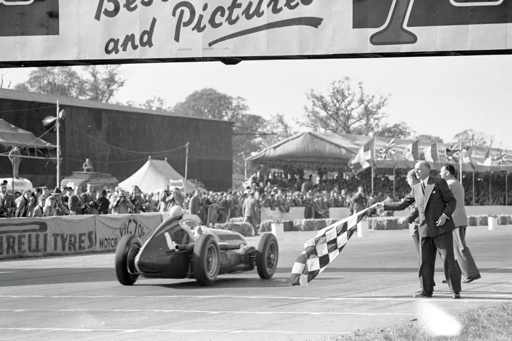 Reg Parnell, Alfa Romeo 158, takes the chequered flag for the final podium position