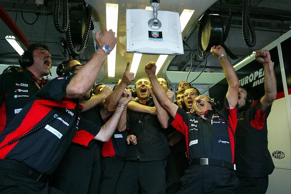 The Minardi mechanics cheer after watching Jos Verstappen clinch provisional pole position