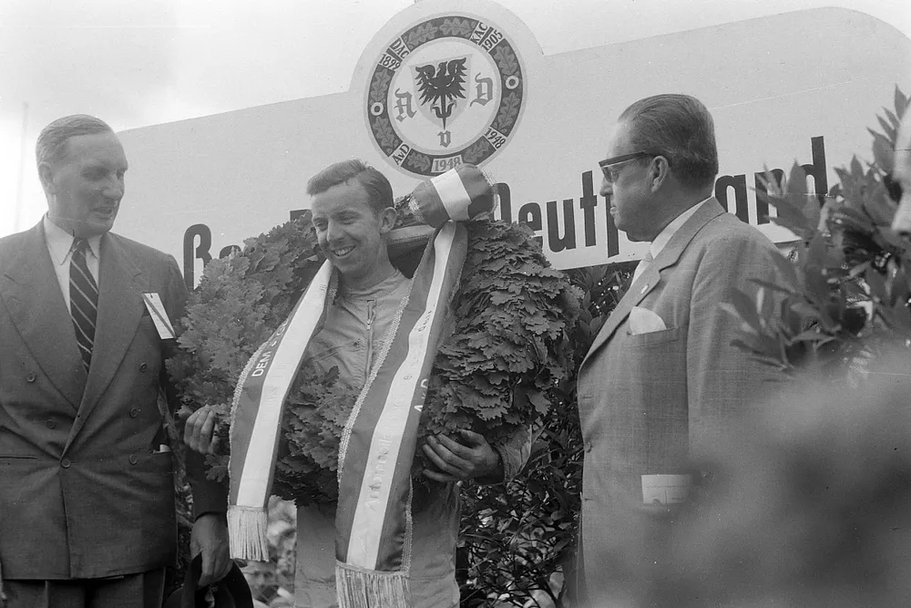 Tony Brooks celebrates victory on the podium
